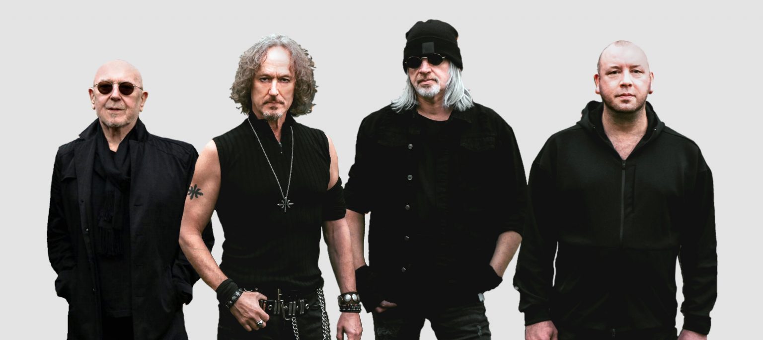 Members of the rock band Nazareth standing in a row beside each other.