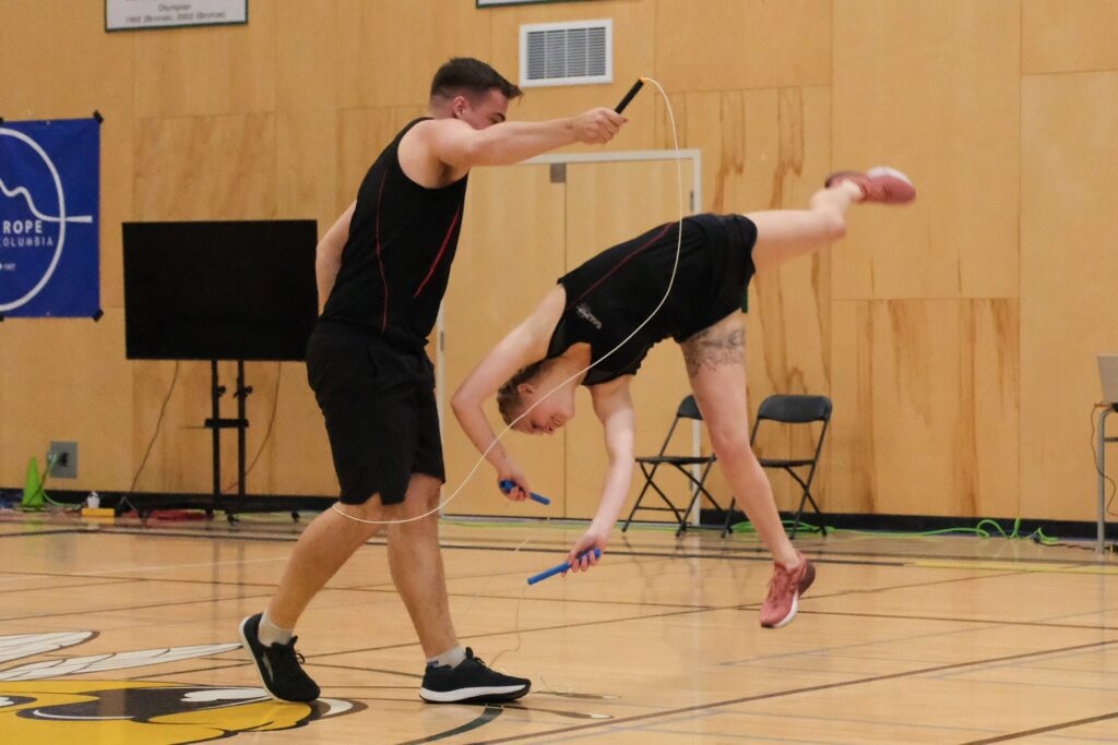 Two people performing a trick with their skipping ropes.